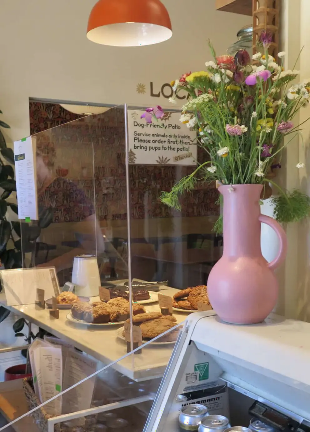 Pastries and pink vase with flowers, in The Grove Bakery and Cafe. 