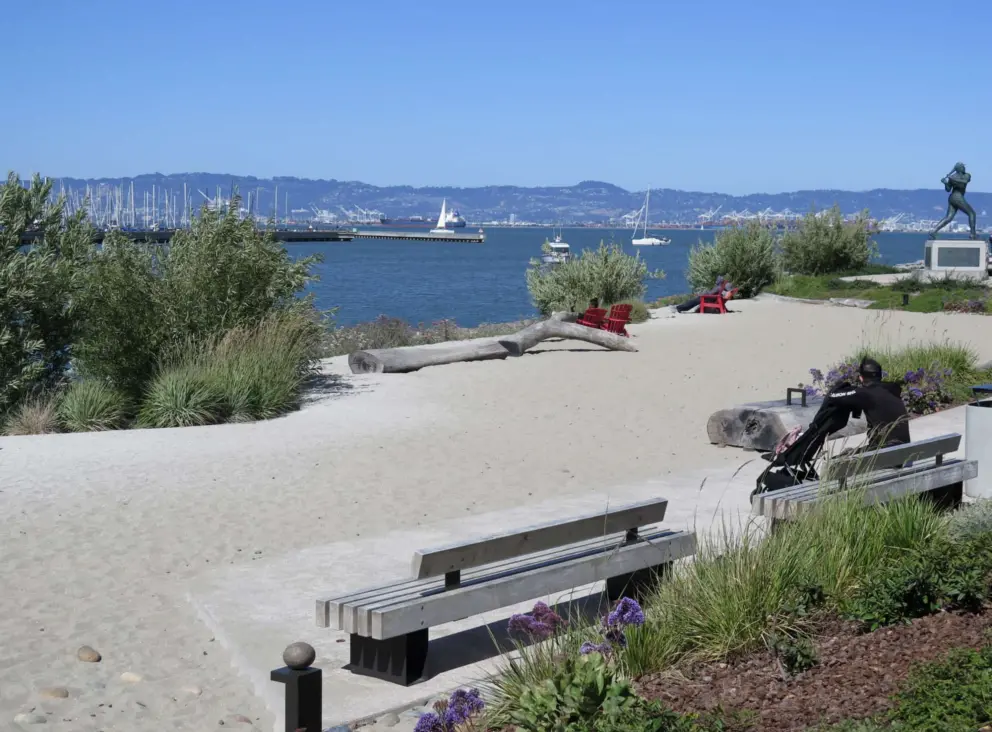 Benches, driftwood, and water views at the sandy area in China Basin Park, near the William McCovey statue. 