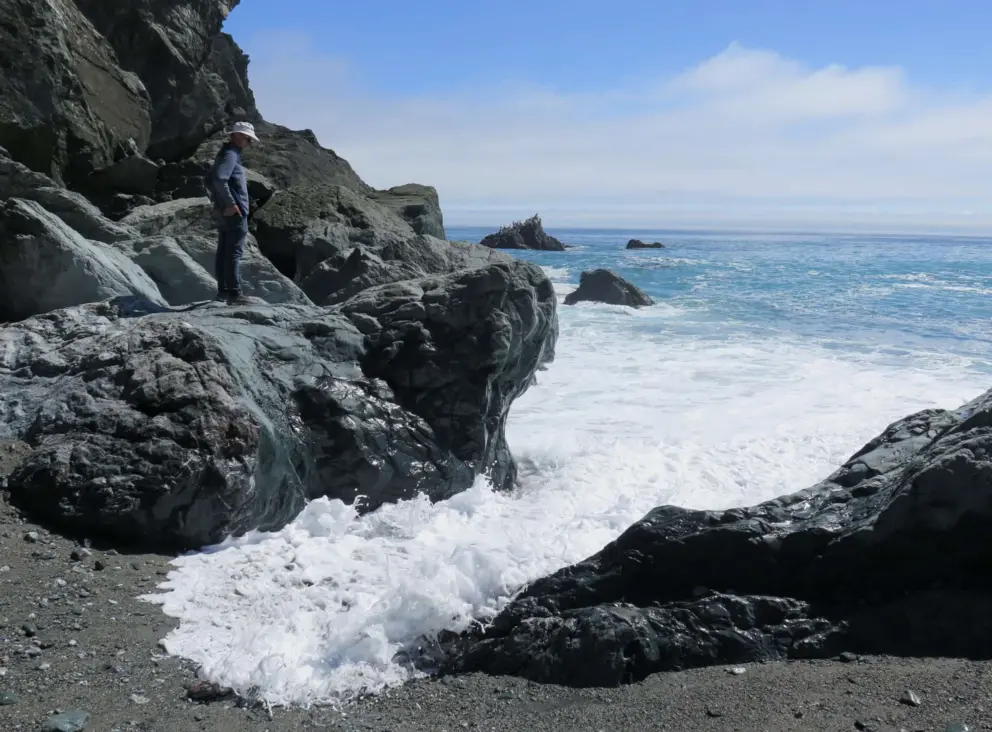 Water swooshing around a big gray rock that you can stand on!