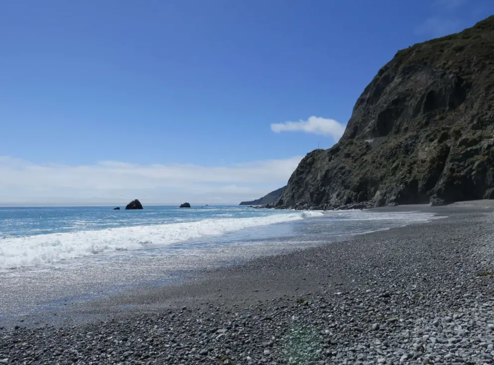 The wonderful pebbles, bright water, and steep cliffs!