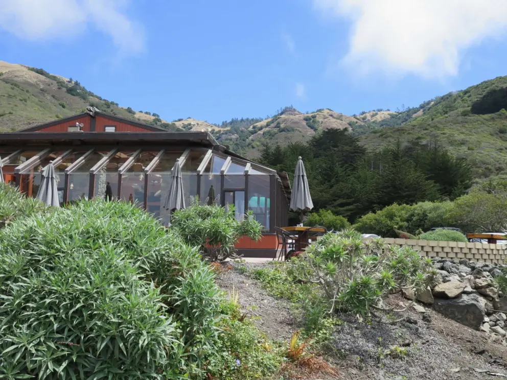 The restaurant with blue sky and hills behind. 