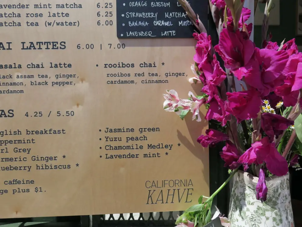 Vase with flowers, and menu board at California Kahve. 
