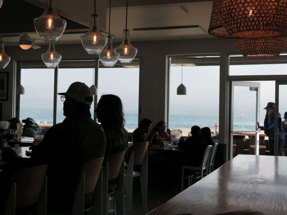 The bar area with vintage lighting and ocean views, at Zelda's on the Beach. 