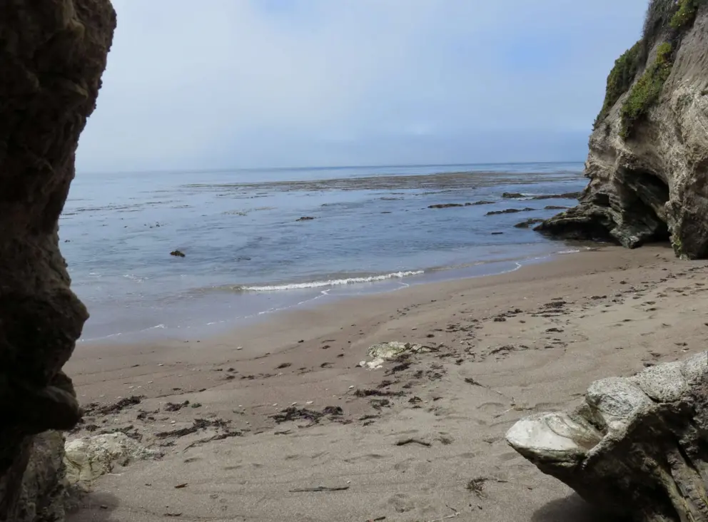 Between two cliffs in a little cove. 