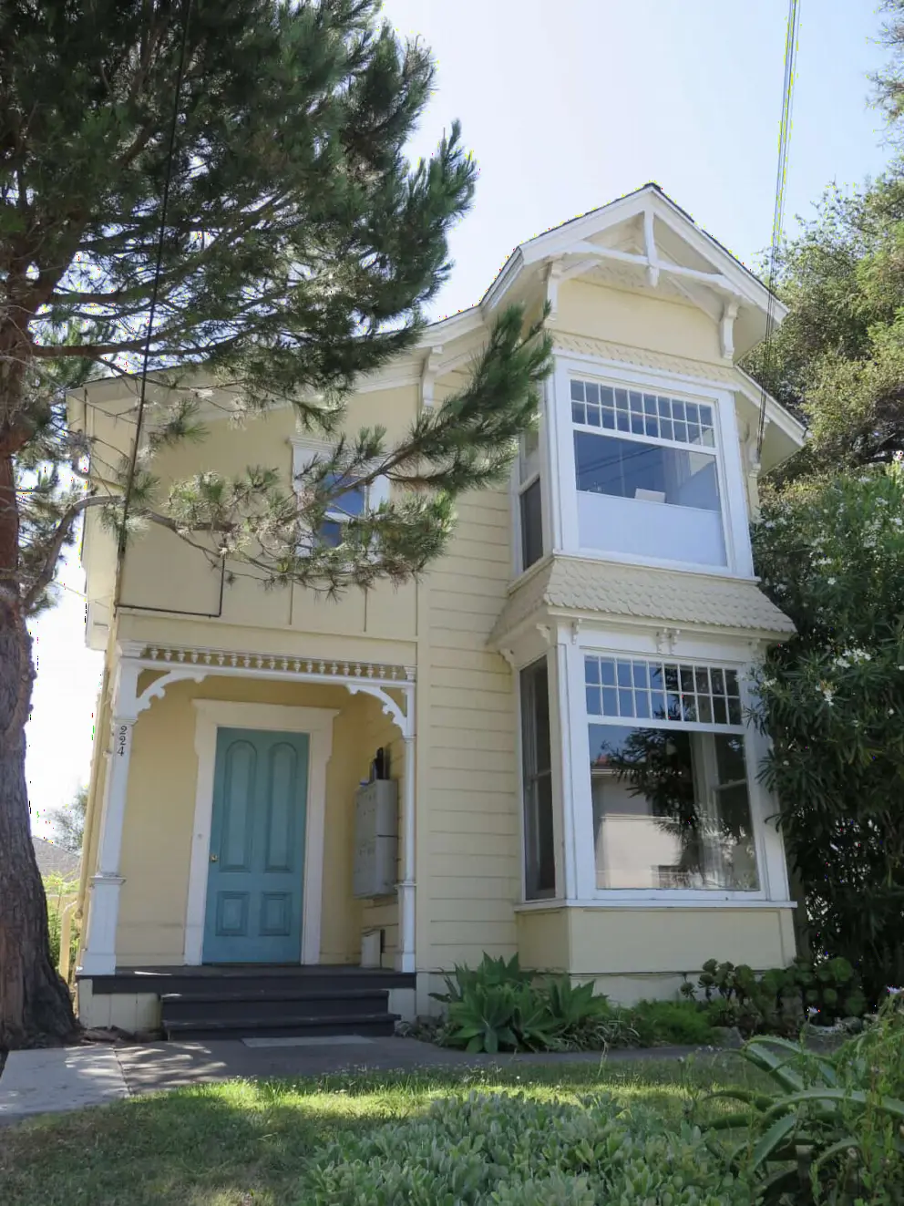 Yellow Victorian house with green door, on East Figueroa Street. 