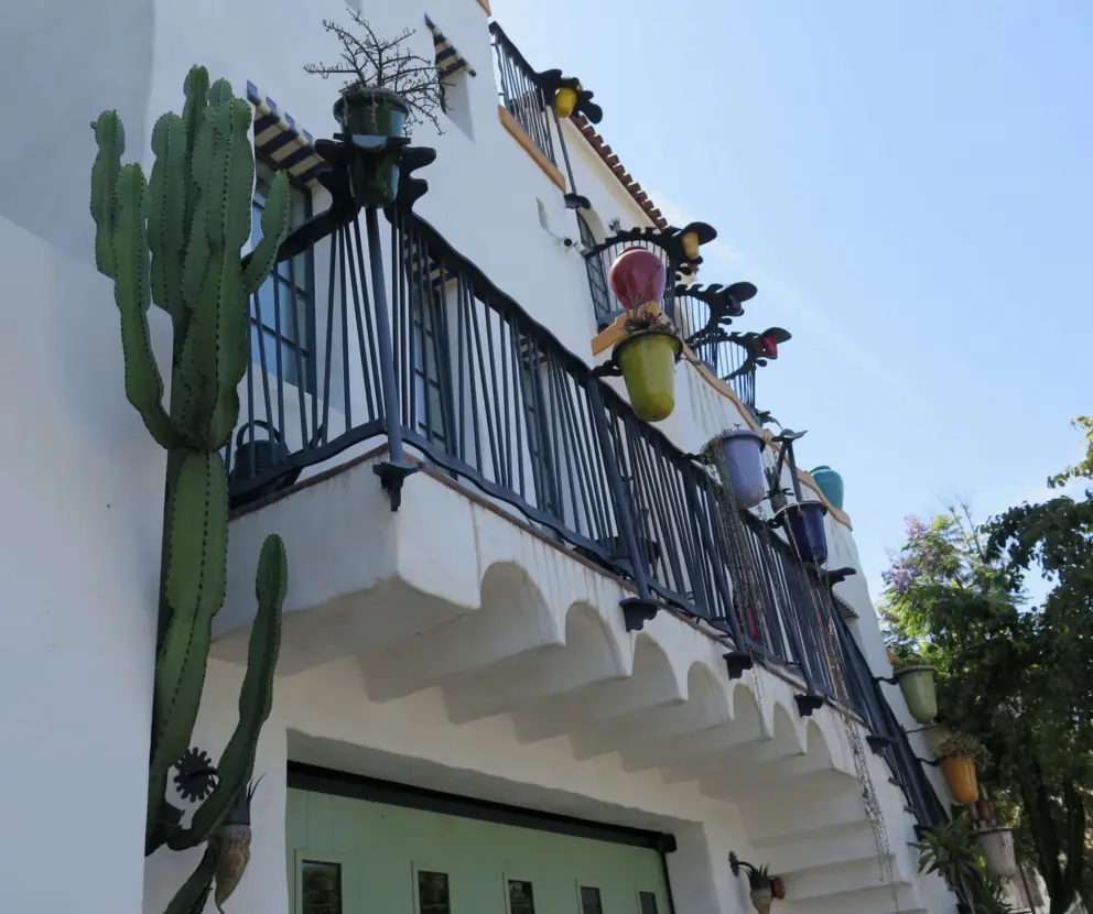 Cactus, colorful pots, and green garage door- a winning combination!