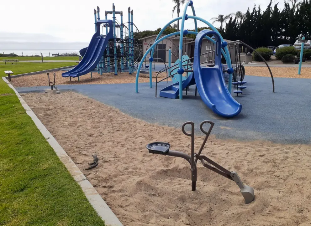 Two scoopers in the sand and the toddler playground. 
