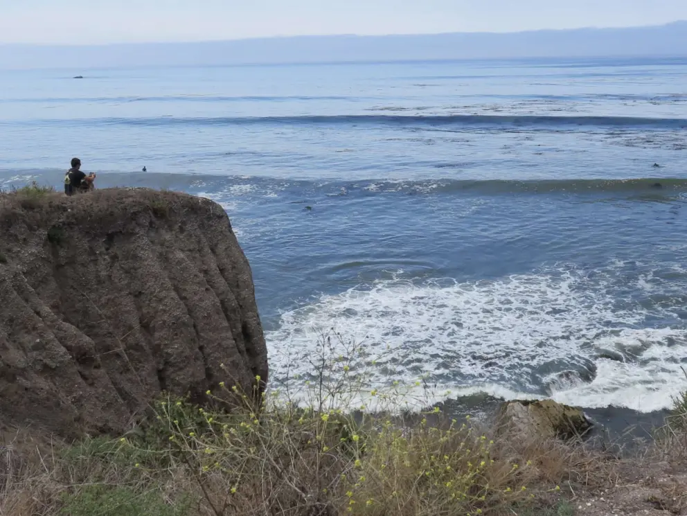 Guy watching the surf on an August day. 