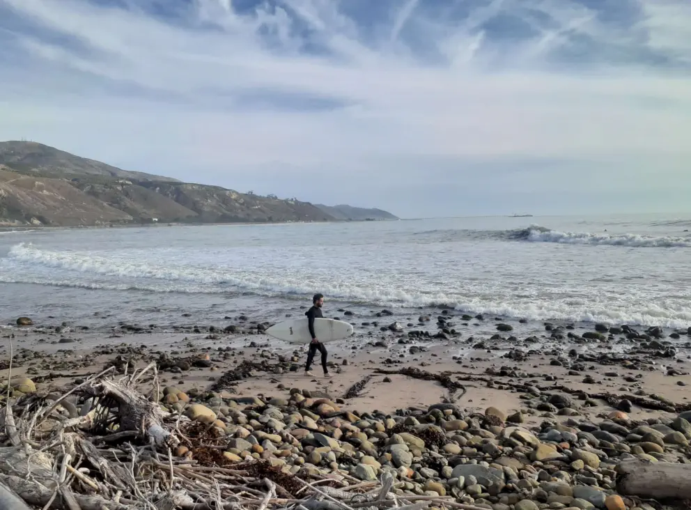 A surfer heads out on a day with huge waves. 