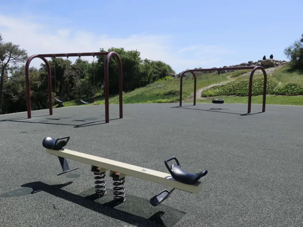 See saw, with swings and lookout in the distance. 