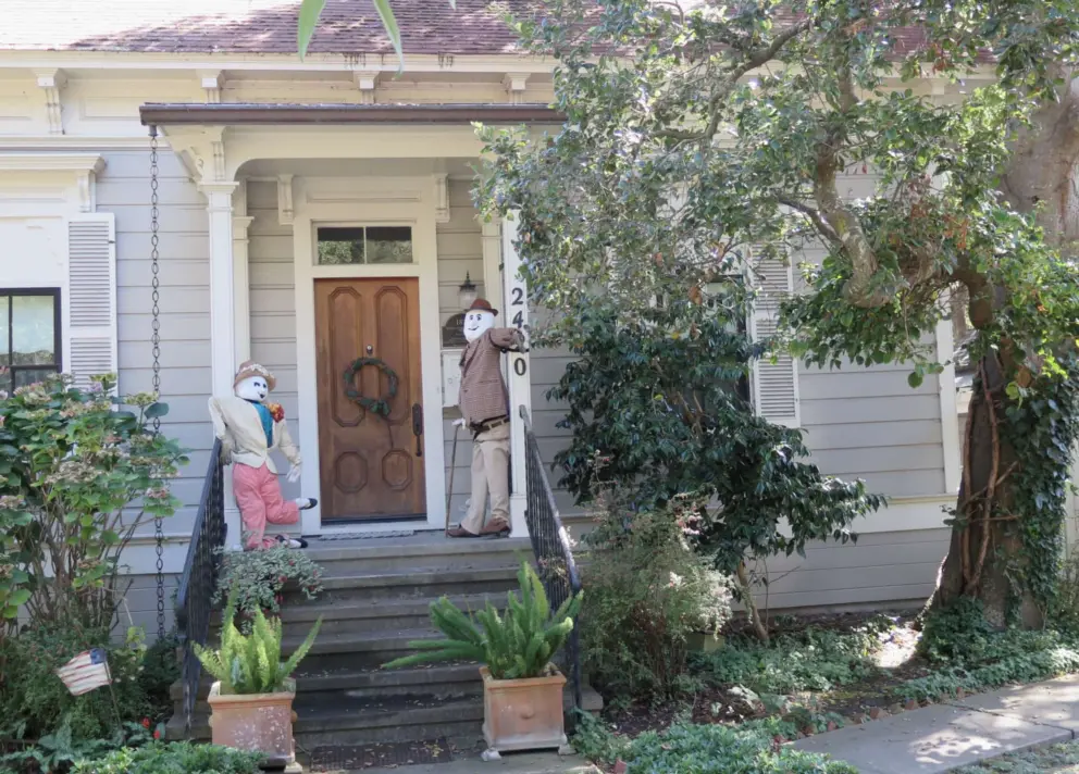 Scarecrows on the porch of a historic building on the east end of Main Street. 