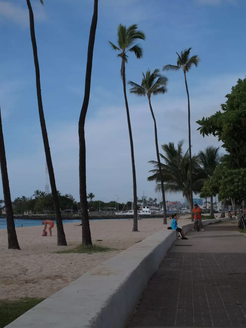 A boy sits by the boardwalk.