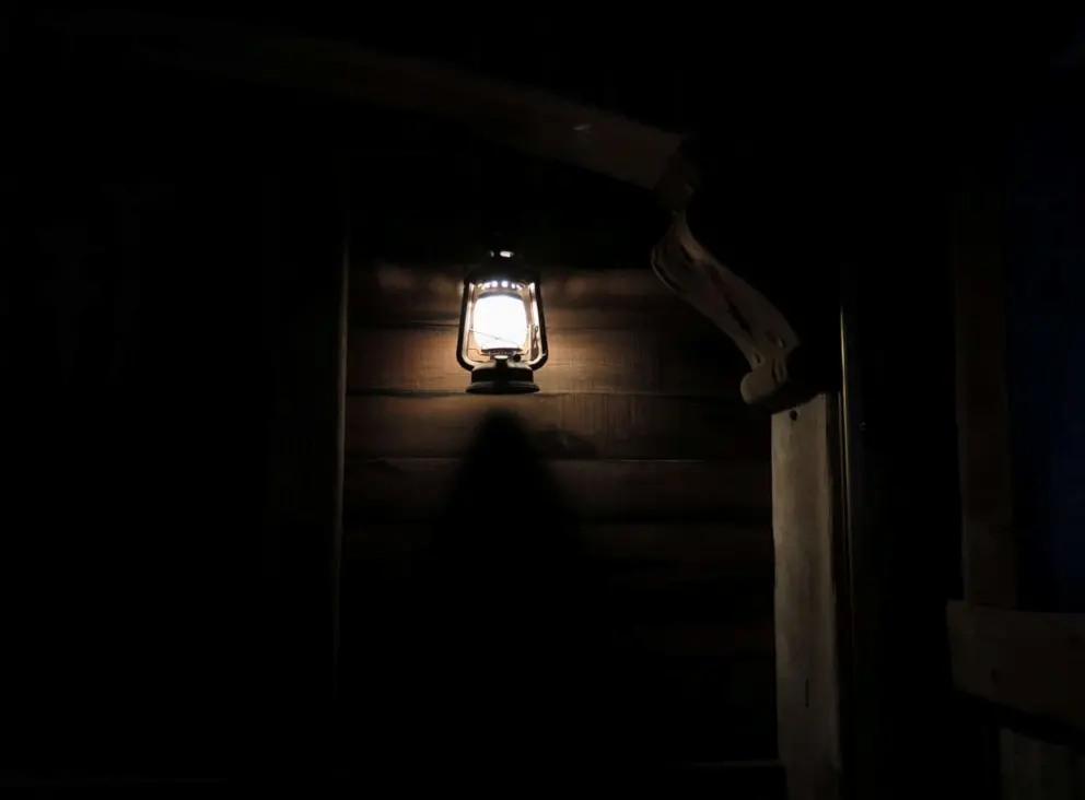 Dark wood and lantern as you descend to the caverns. 