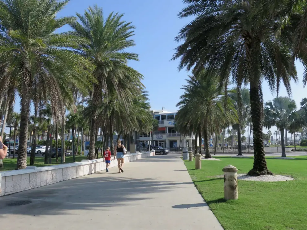 A mom and son walk through the park toward Coronado Drive and Ron Jon Surf Shop. 