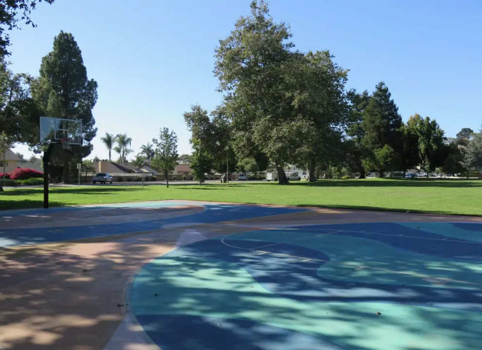 The colorful basketball court and large lawn.