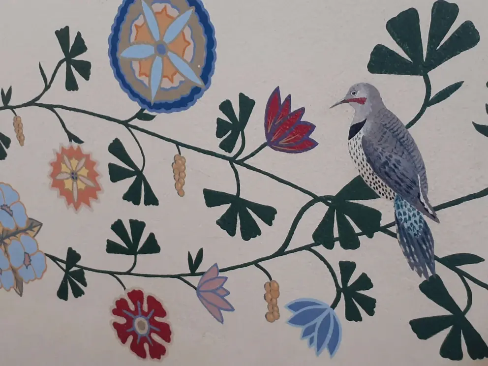 A bird and flowers painted on the walls. 
