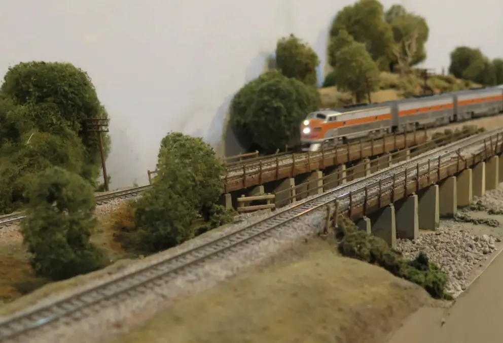Mini train cruising over a bridge. 