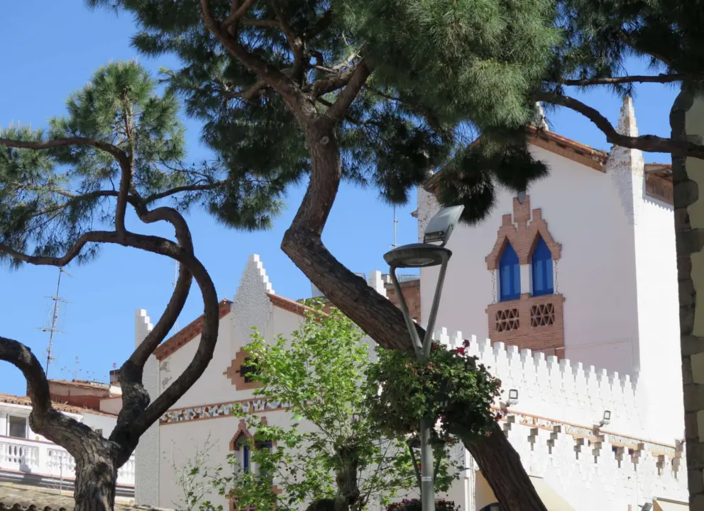 White washed side of the church with pointed decoration.