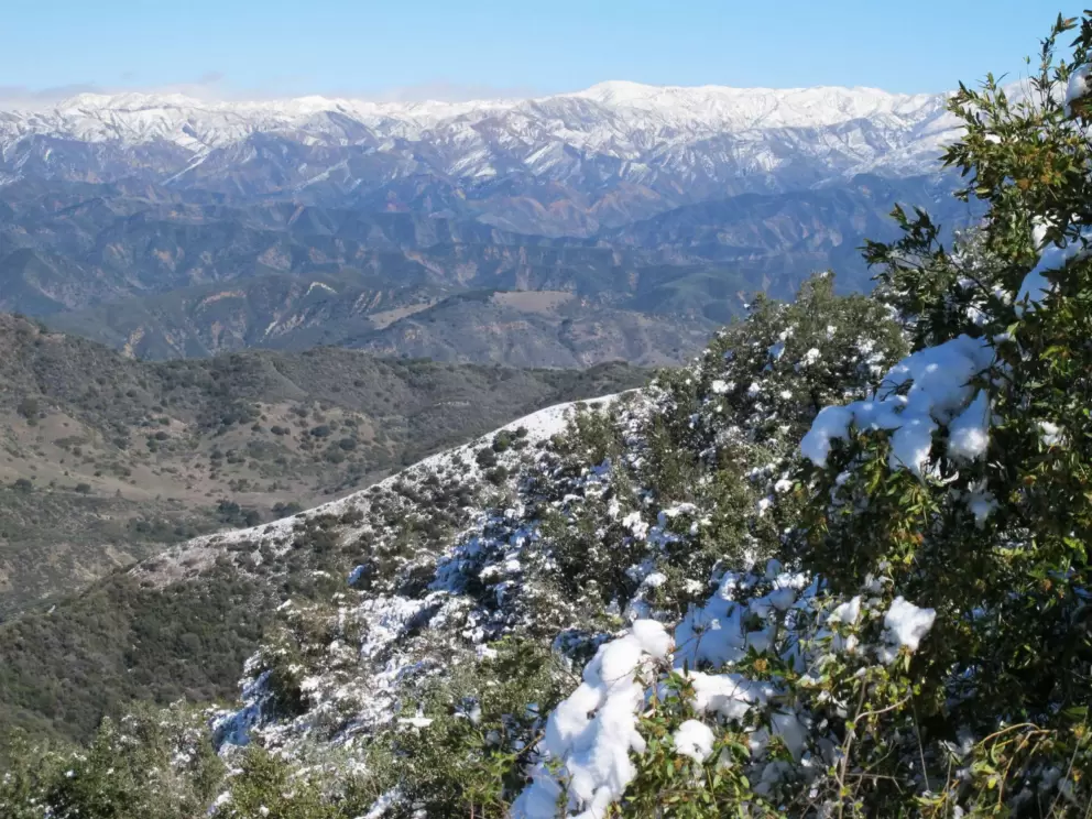 Snow at the top and mountain ranges behind.