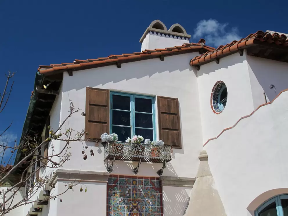 Spanish architecture at Adamson House- round deeply-set window, ironwork flowerbox, wooden shutters.