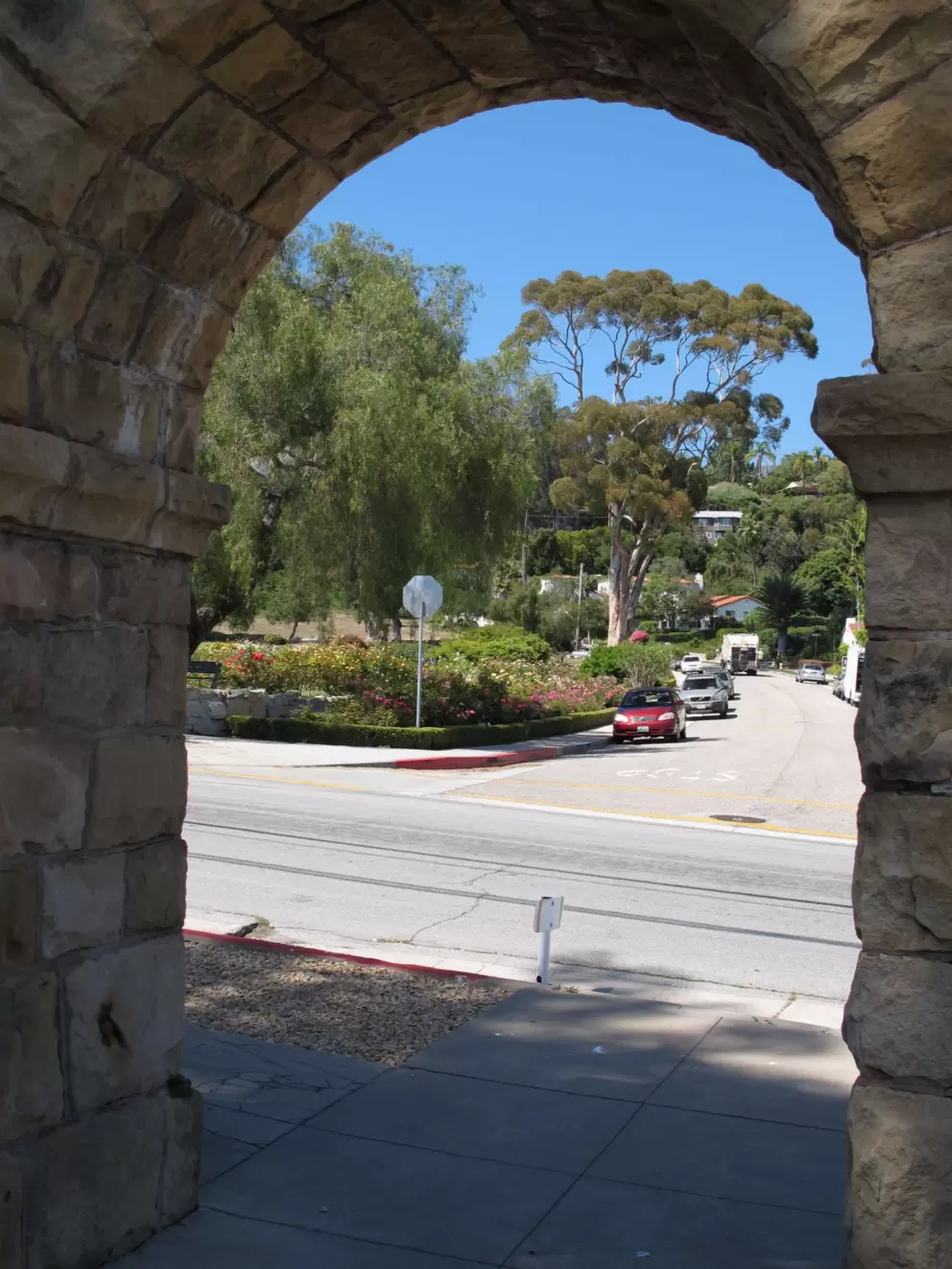 Looking through Junipero Plaza archway to the mission rose garden.