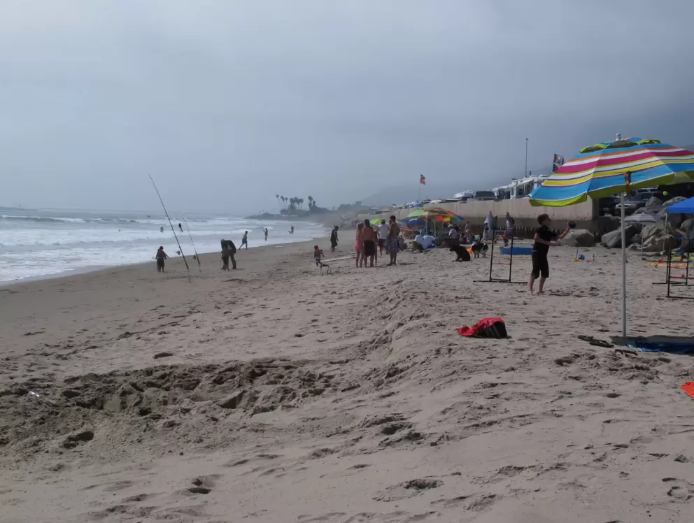 Fishermen enjoy the beach. See the RVs behind.