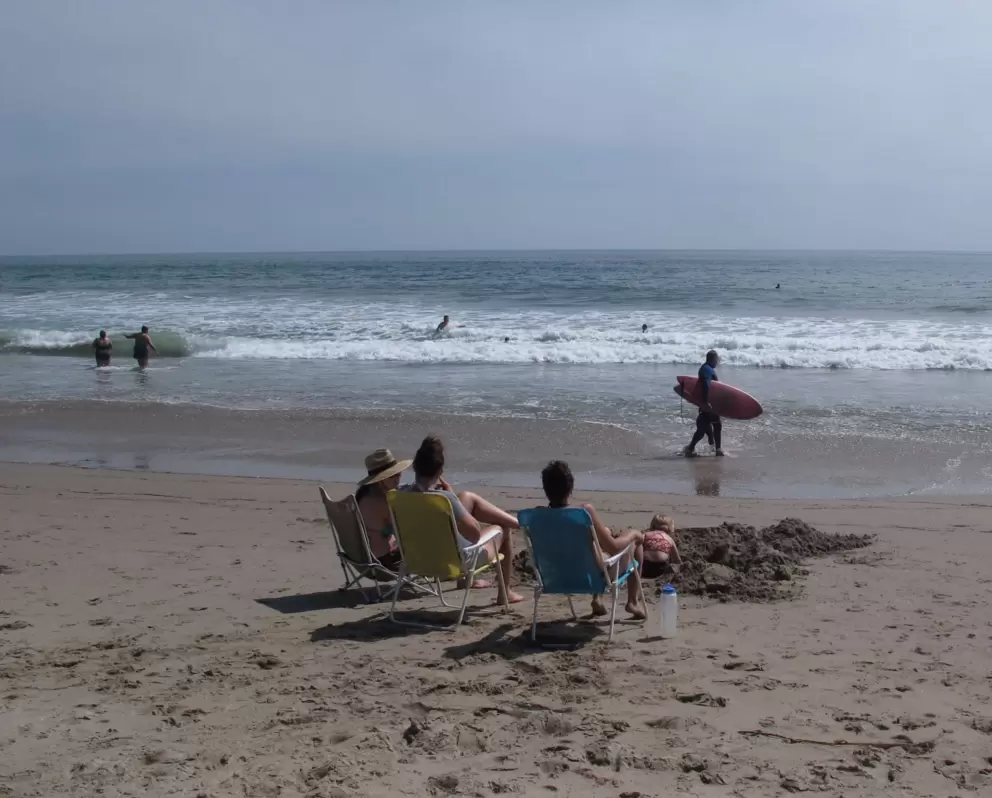 Surfer at Faria Beach, and child digging in the sand.