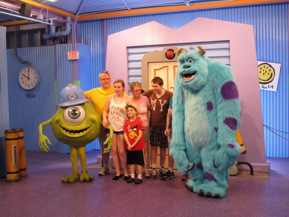 A family greets characters from Monsters Inc.