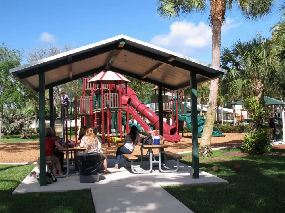 Sheltered picnic tables beside the playground.