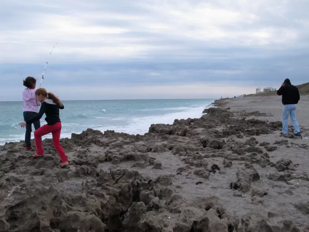 Kids playing on the limestone rock at the shoreline.