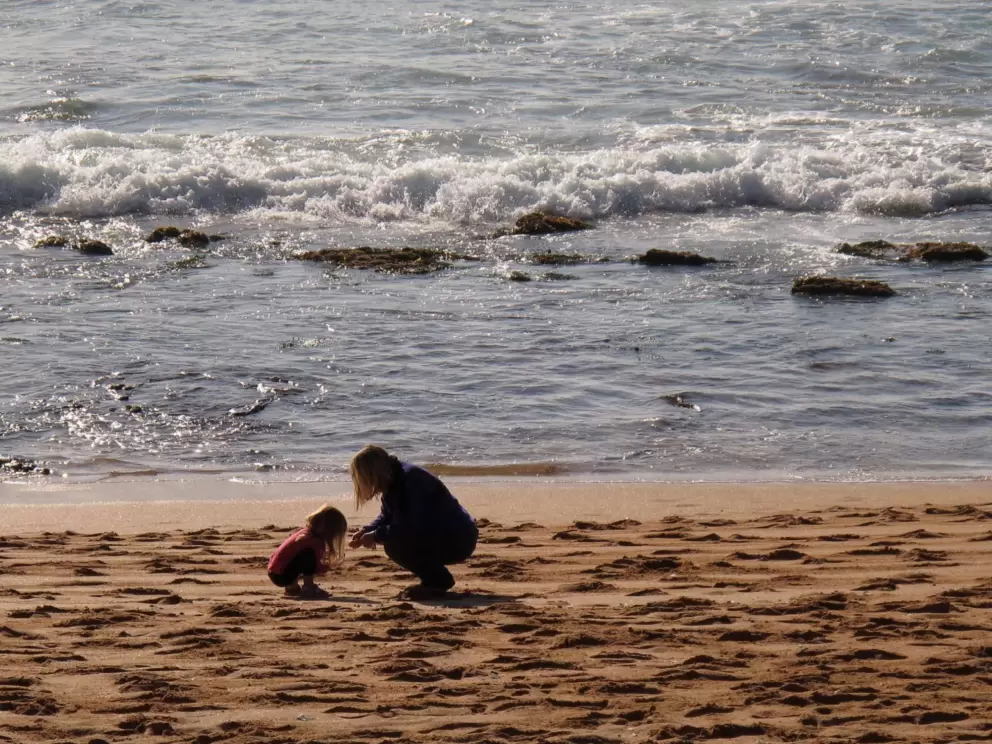 Mommy and daughter exploring the beach.