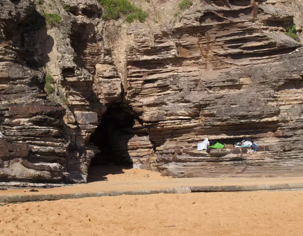 Swimmers store their clothes on rock ledges by the cave.