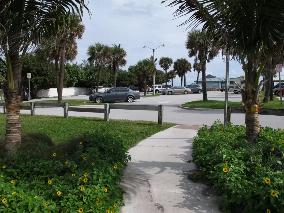Walking path with flowers on either side, leading into the parking lot.