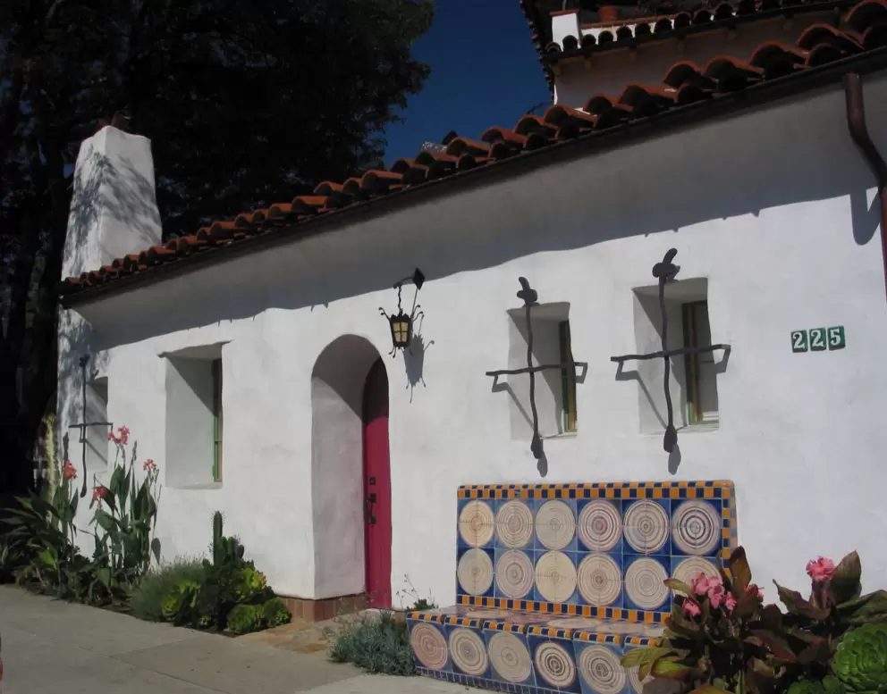 Notice the ironwork lantern and window grills. Notice the red door, the ceramic bench, and the rose cactus.