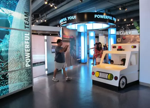 Toddlers climb into and drive an ambulance.