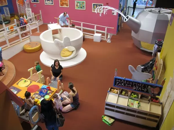 Mothers chat while their kids entertain themselves.