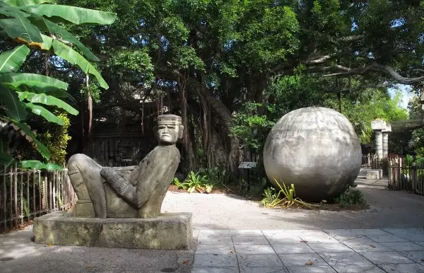 Geometric ball sculpture and man reclining- these are found in the Yucatan.