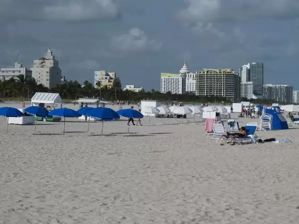 Blue umbrellas, white umbrellas, and Miami skyline.
