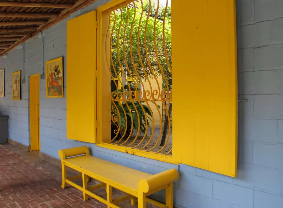 Bold yellow bench and pale blue wall.