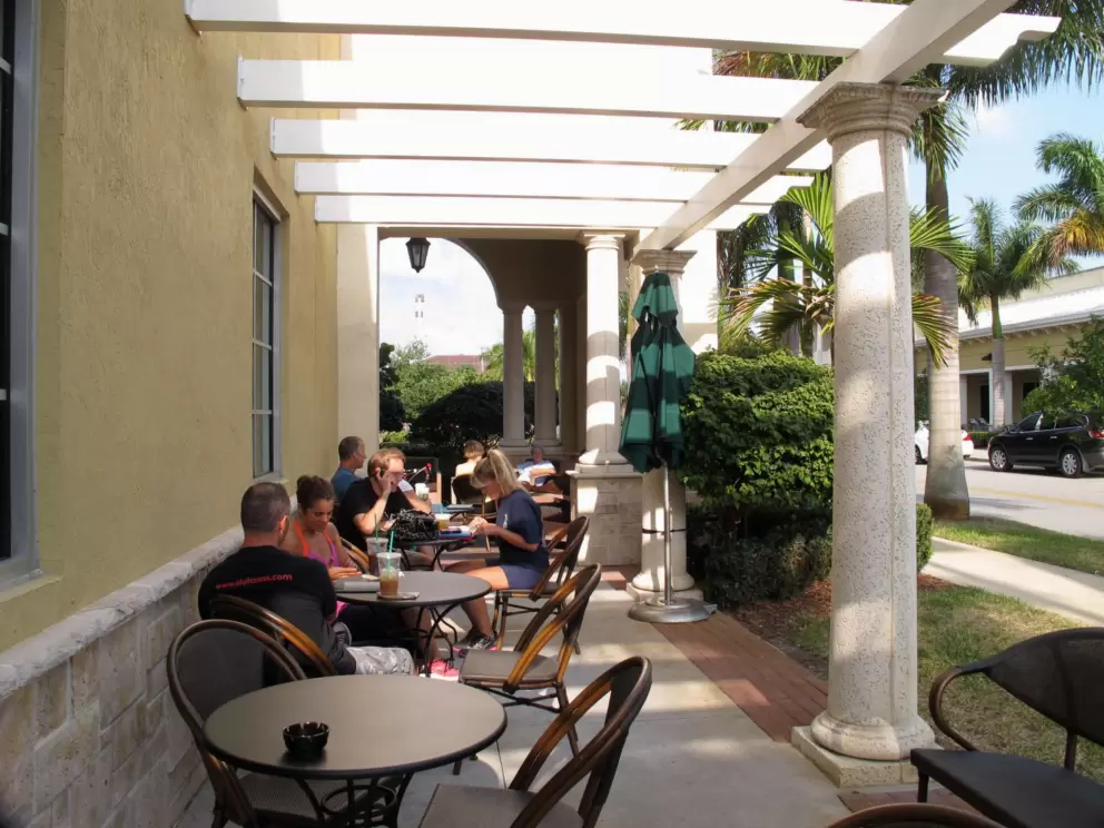 The Starbucks at Sea Plum Town Center has outdoor seating surrounded by bright tropical foliage.