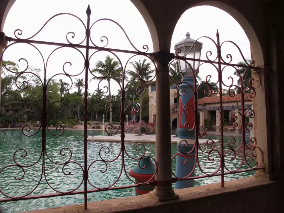Looking through the entry building at the pool. Archways and pink wrought-iron.