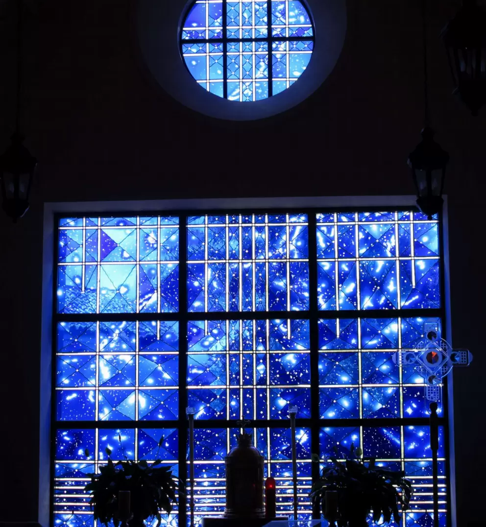 A small side chapel with magical deep blue stained glass depicting the universe.