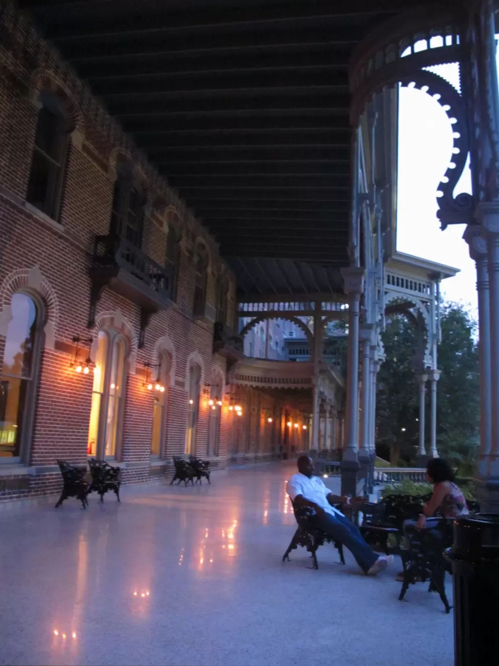 People enjoying a warm summer night on the front porch of Plant Hall.
