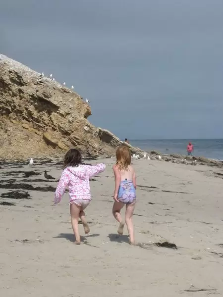 Girls running along the beach on a summer day.
