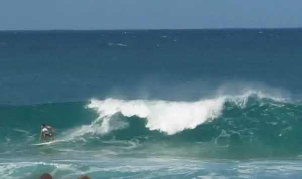 A surfer catches a ride at Pipeline.