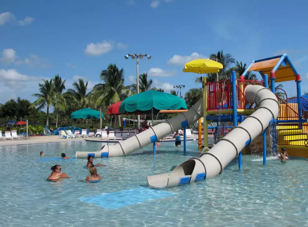 Moms taking a dip while their kids enjoy the splash playground.