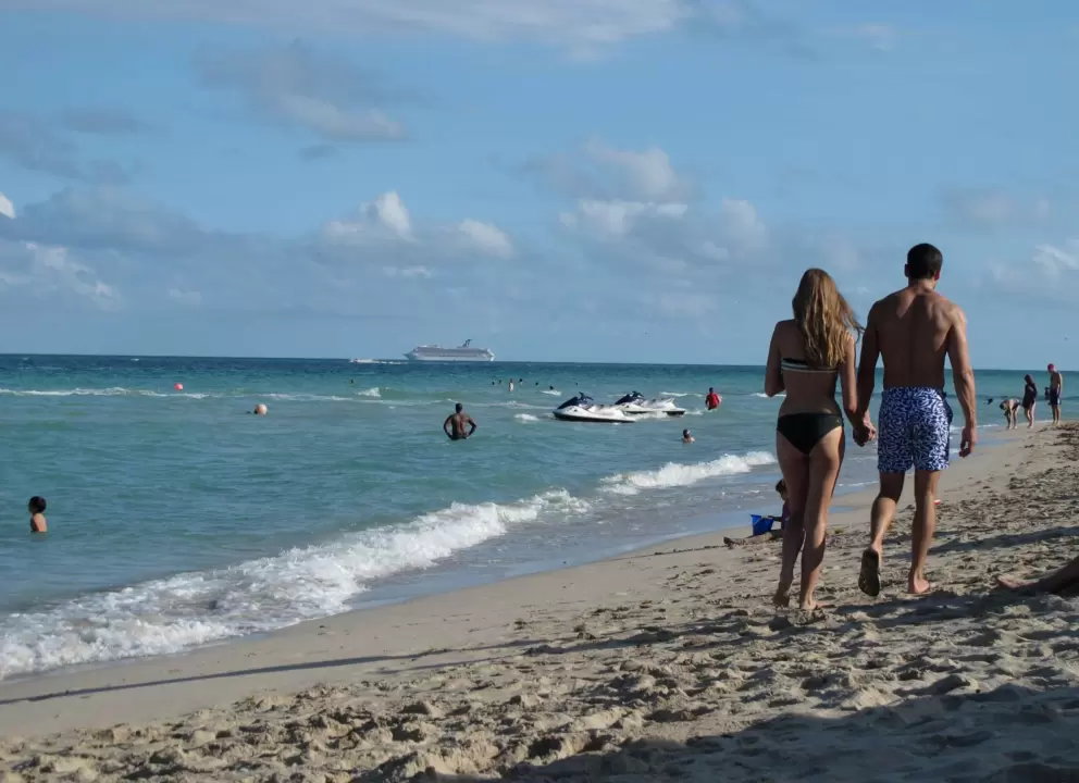 A couple enjoys a late afternoon stroll at the shore.