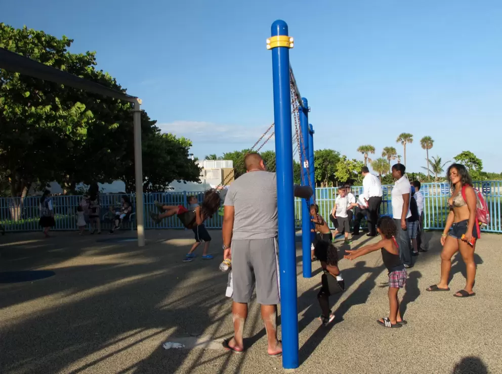 Beachgoers gather by the swings.