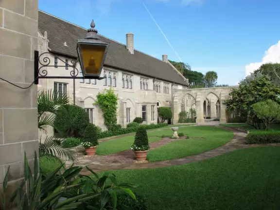 Delightful garden behind a gothic church, with lily pond, koi fish, tropical flowers, sculpted coral walls, fountain, and fresco.