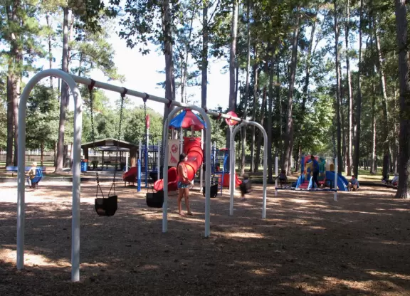 Super fun playground with merry-go-round and tons of climbing structures, all under the shade of tall trees.